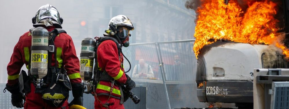 deux pompiers éteignent un incendie